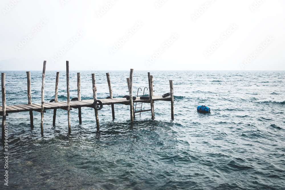Dock with stormy waves along lake Atitlan at the coast of Jailbalito, Guatemala