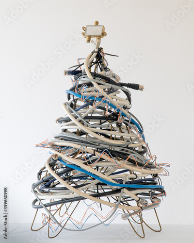 A geeky Christmas tree made of coax cables, telephone cords, and a splitter on a white background. photo