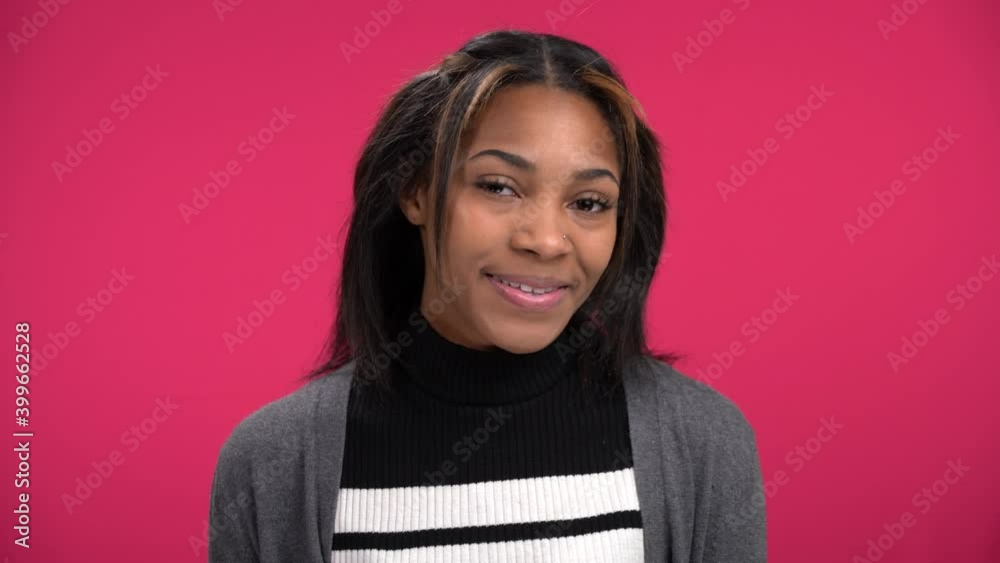 Pretty young African-American woman smiles bats eyes at the camera Pretty young African-American woman smiles bats eyes at the camera