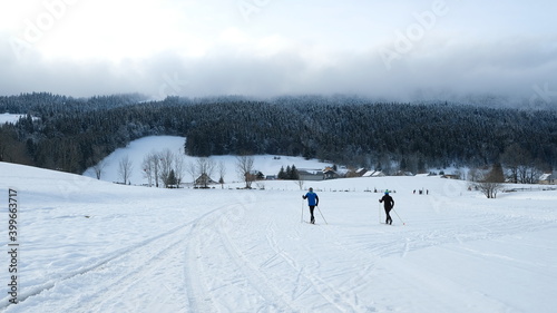 Deux personnes à ski de fond dans une station de ski