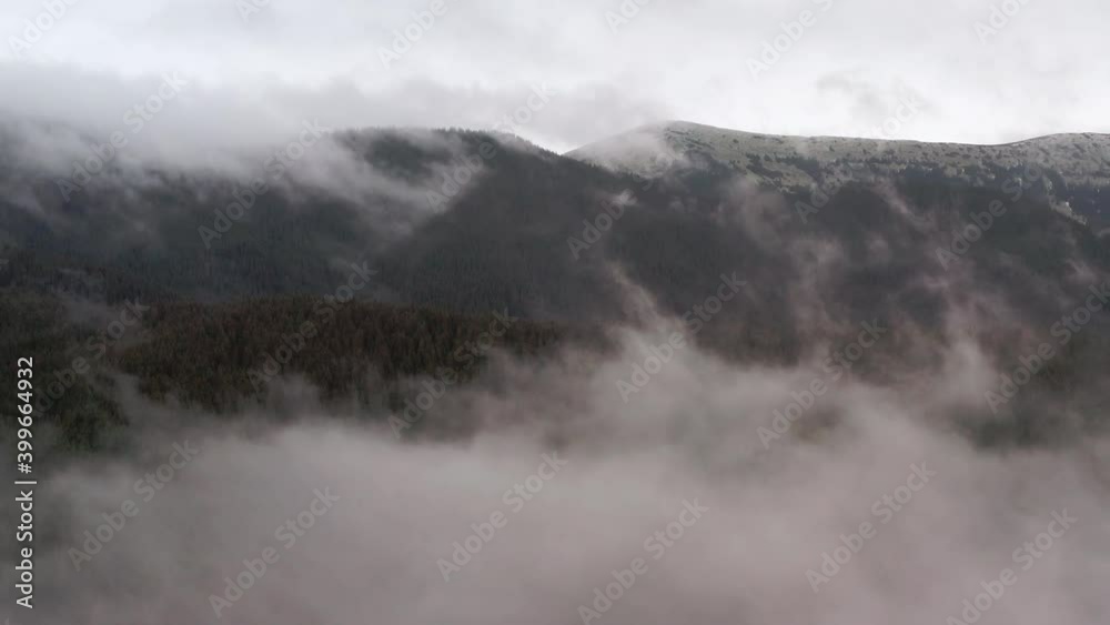 Aerial view. Mysterious mountain landscape on a cloudy autumn day. Foggy forest in the highlands. Natural background. Carpathian mountains. Cloudy gray winter landscape Aerial view. Mysterious mountain landscape on a cloudy autumn day. Foggy forest in the highlands. Natural background. Carpathian mountains. Cloudy gray winter landscape