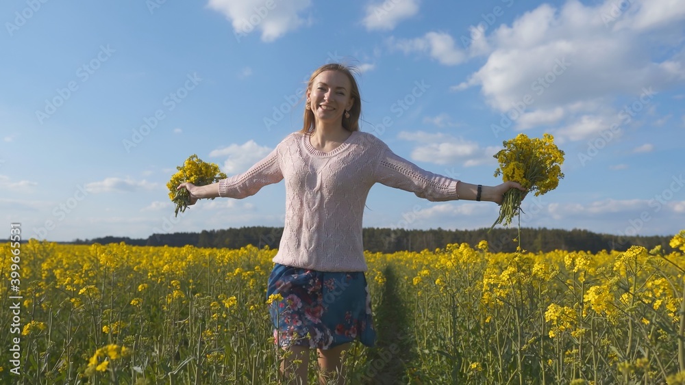 Happy girl with a bouquet of rapeseed flowers in a yellow rapeseed field. Happy girl with a bouquet of rapeseed flowers in a yellow rapeseed field.