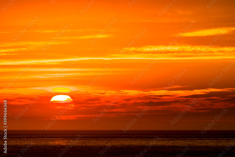 Sun shining through Clouds at Sunset over Ocean