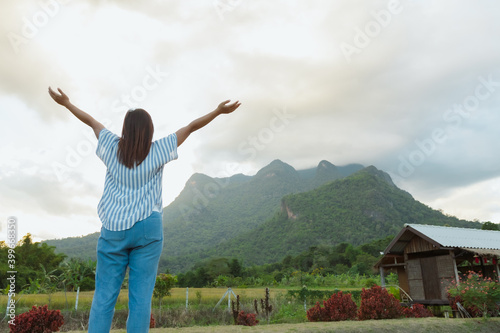 Backside of woman is enjoying with beautiful nature of mountain and sky while she travel on her vacation.