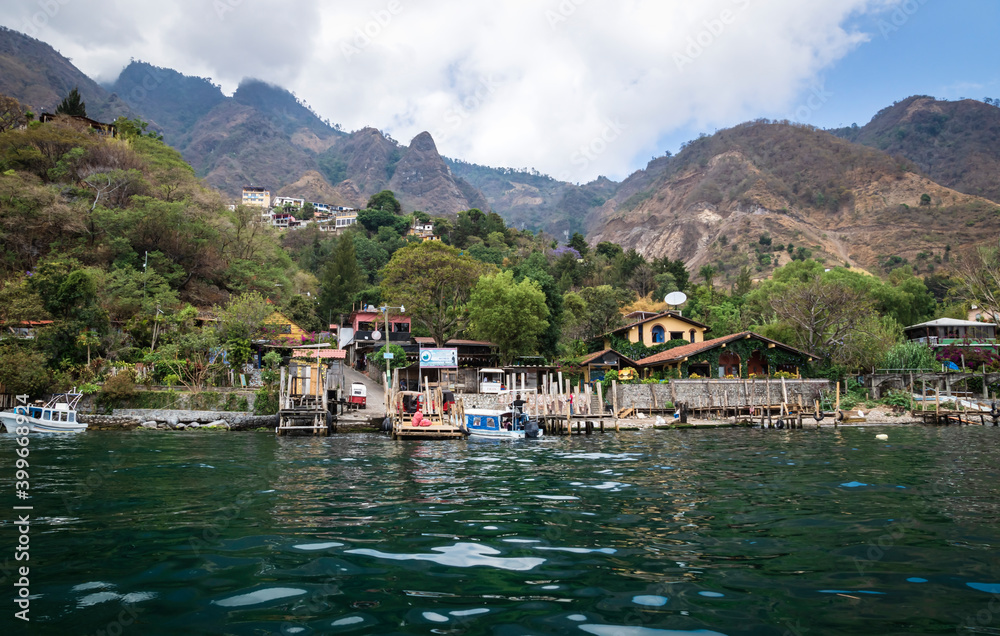 View from lake Atitlan to the coast with boat docks of the mountain village Santa Cruz la Laguna, Guatemala