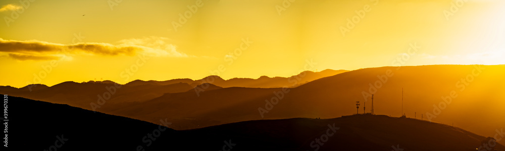 Panoramic sunset of silhouette of mountains at sunset