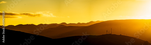 Panoramic sunset of silhouette of mountains at sunset