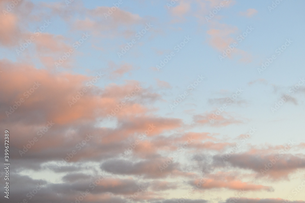 Peaceful pastel light in an evening sky, blue sky and fluffy clouds as a nature background
