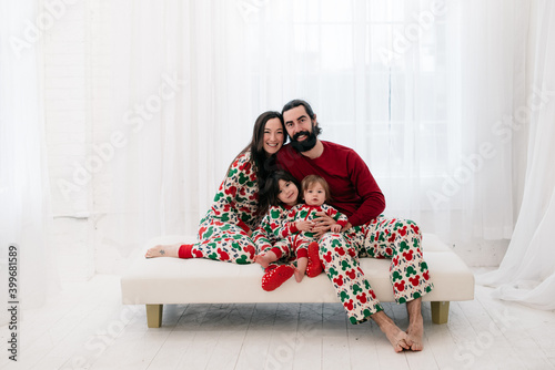 Fotografija Family portrait of mother, father, two children in matching Christmas pajamas in