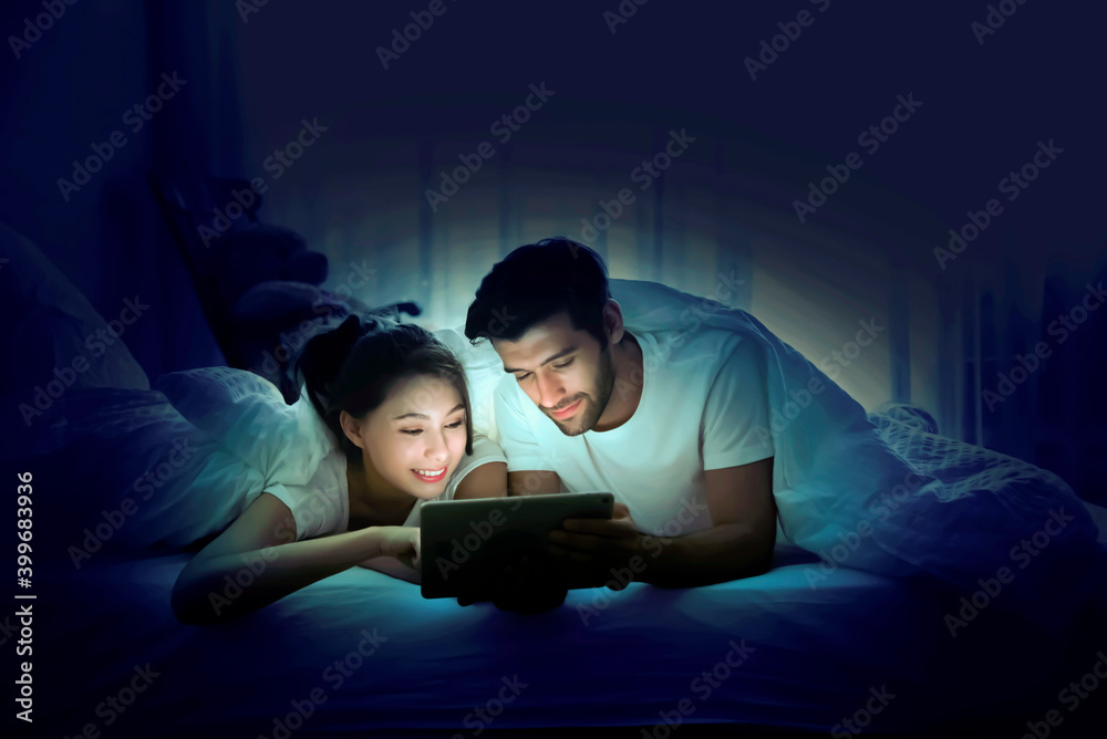 Young people are sleeping in bed watching movies from laptop with happiness. Young people are sleeping in bed watching movies from laptop with happiness.