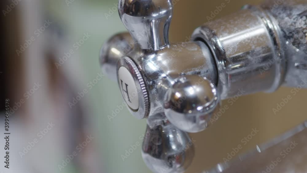 Hand turns loose hot water handle for bath, close Hand turns loose hot water handle for bath, close