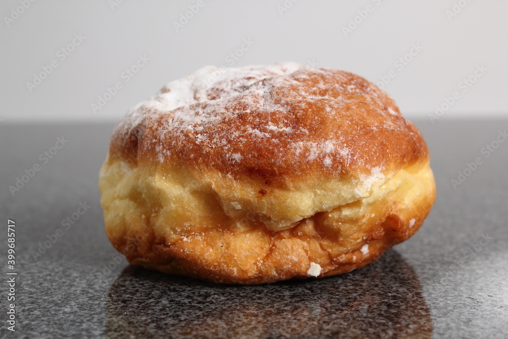 Doughnut without a hole filled with jam with sugar on top Doughnut without a hole filled with jam with sugar on top