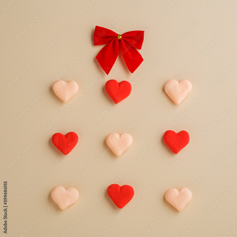 Hearts are laid out in a square and a ribbon bow. Valentine's day card.