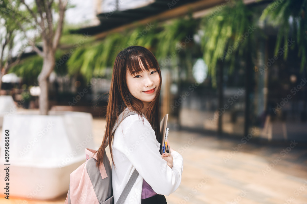 Portrait of young adult asian college student woman with notebook on day in the city. Portrait of young adult asian college student woman with notebook on day in the city.