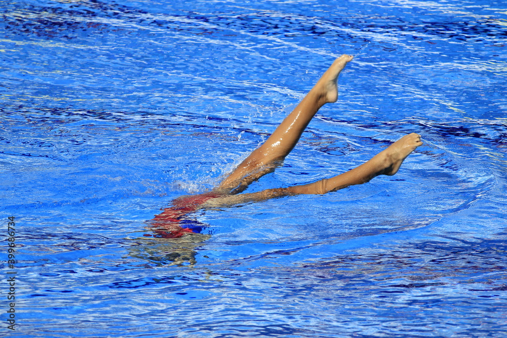 A swimmer's feet are above the surface of the water when half of his body and head are submerged