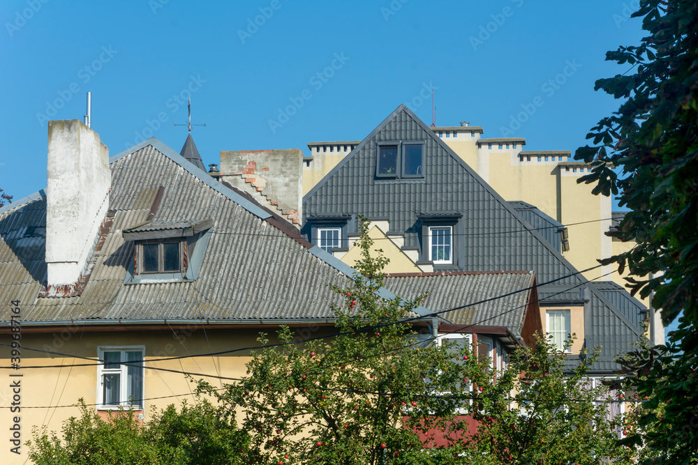Skylights on roof of multi-storey building. Attics and chimneys in architecture. Selective focus, blur