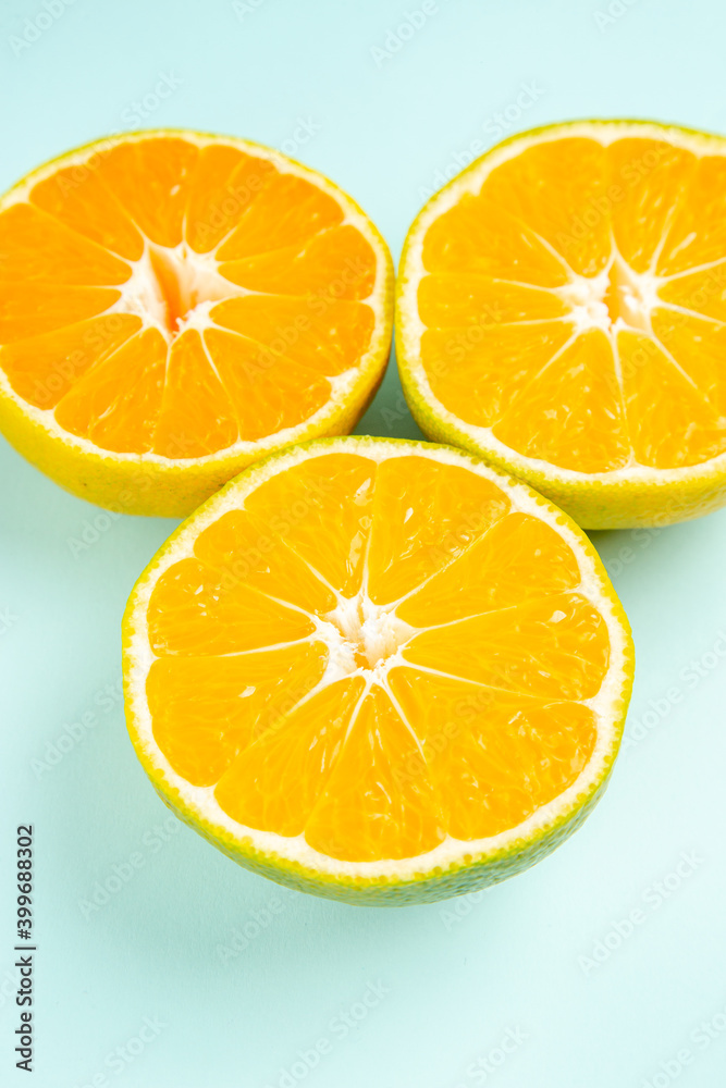 Fototapeta premium front view fresh tangerine slices on light-blue desk photo color orange citrus fruit