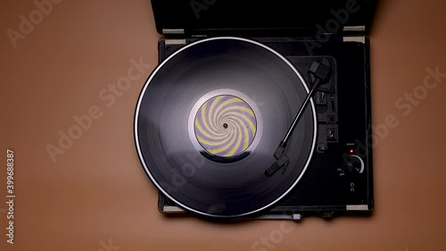 The man shifts the needle on the vinyl record. Top view of male hands and vintage turntable on brown table background. Retro concept. Slow motion. Close up. photo