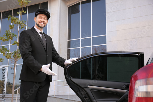 Portrait of handsome chauffeur near luxury car photo