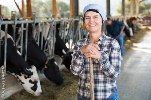 Portrait of woman who is standing near cows at the farm.