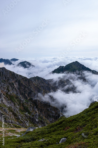 Rock formations in grassy mountains above the clouds in early autumn at Mount Kisokoma in Nagano Prefecture, Japan.