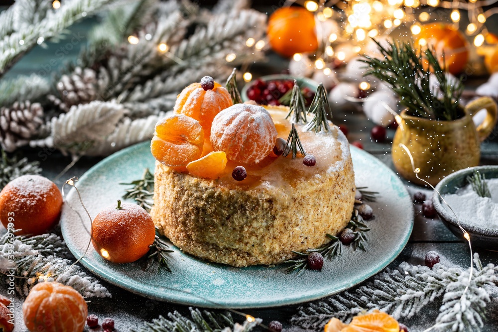 Christmas fruit cake, decorated with tangerines, rosemary in the form of Christmas trees. atmospheric photo Christmas fruit cake, decorated with tangerines, rosemary in the form of Christmas trees. atmospheric photo