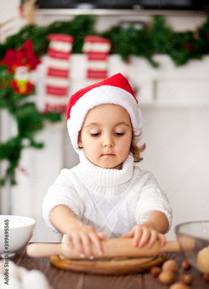 Funny girl in a Santa cap baking christmas cookies at home Funny girl in a Santa cap baking christmas cookies at home