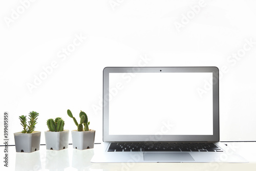 White screen computer laptop with cactus and succulents plant on the table on white wall background, copy space input text concept and smart technology idea