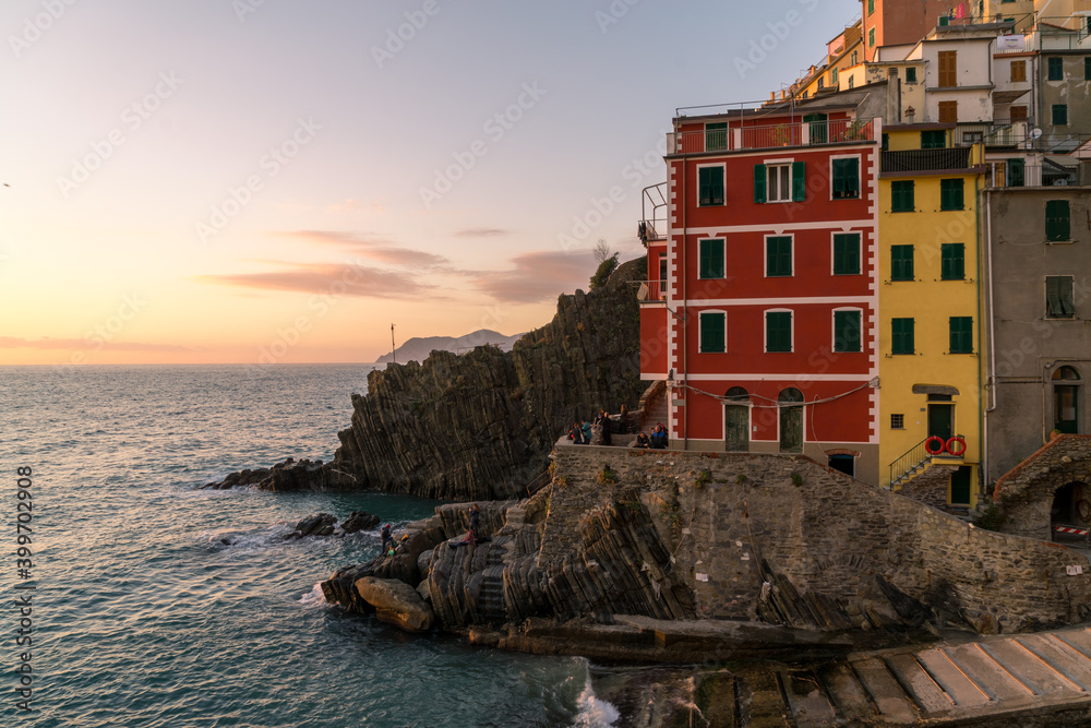 Riomaggiore at a sunset. It is one of colorful villages of Cinque Terre in Italy, suspended between sea and land