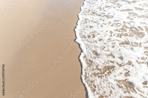 Fotografie Sparkling waves hitting the shore on the beach, sand beige background image