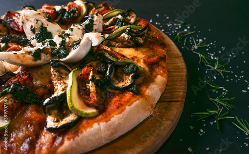 Tasty pizza ratatouille and ingredients for cooking Roasted zucchini tomatoes, fresh basil cheese on black wooden background. Top view of hot pizza. With copy space for text. Flat lay. flag