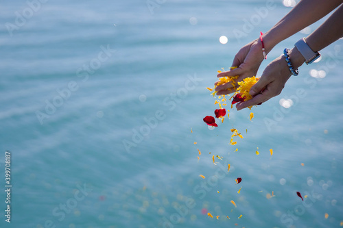 daughter scatter petal of flower on the sea in her father pass away ceremony