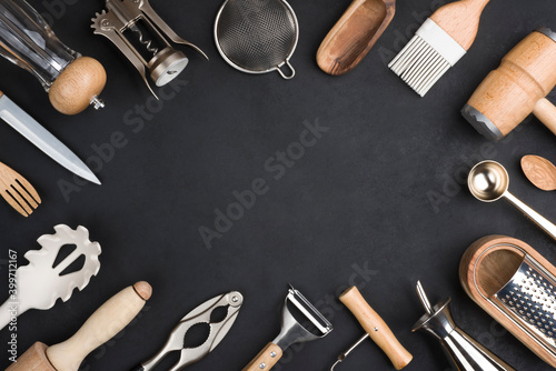 Various kitchen utensils set on black background with copy space photo