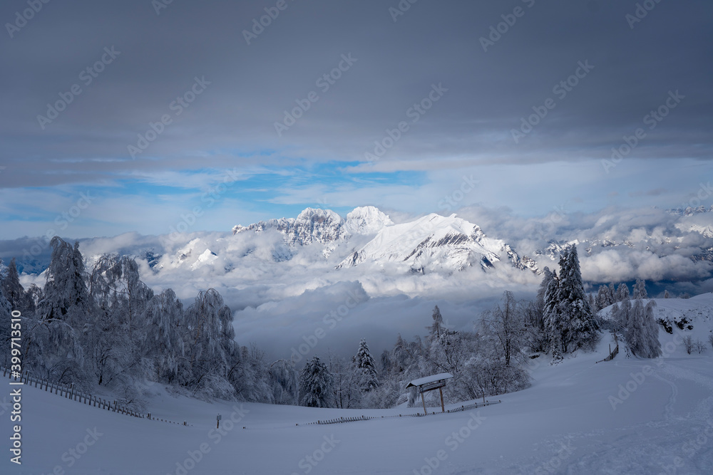 snowy mountain panorama with partly cloudy blue sky