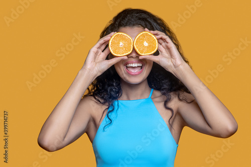 Young dark-haired woman with orange in hands