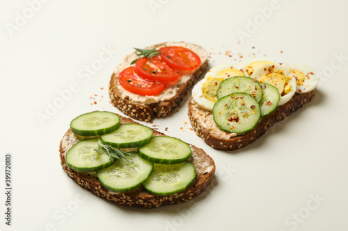 Tasty toasts with different topping on white background