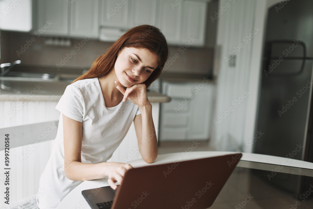 Woman at home in front of laptop sitting at the table working office Woman at home in front of laptop sitting at the table working office