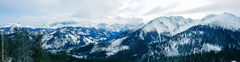 Panorama of snow-capped mountains, snow and clouds on the horizon