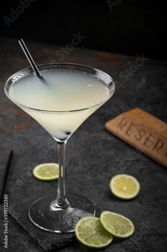 Classic Daiquiri cocktail of rum and lime juice on a dark stone background