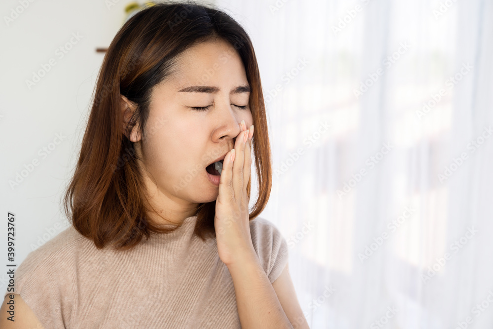 Asian woman yawning wake up not feeling fresh , no energy in the morning Asian woman yawning wake up not feeling fresh , no energy in the morning