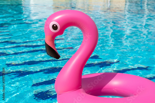 Tropical background. Pink inflatable flamingo in pool water for summer beach background. Minimal summer concept. © Maksym