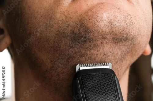 Man shaving his short stubble. Irritation after electric razor shaving concept. 