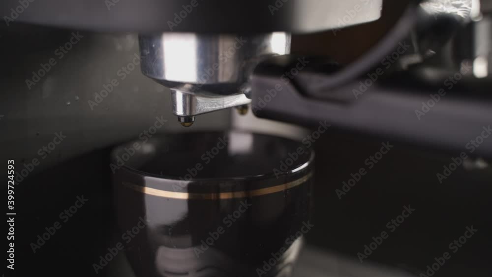 Close up coffee maker machine with black coffee cup. Coffee machine prepares. Coffee espresso preparation. liquid droplet from filter. Close up coffee maker machine with black coffee cup. Coffee machine prepares. Coffee espresso preparation. liquid droplet from filter.