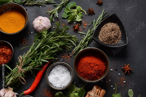 Variety of spices and herbs on kitchen table. Colorful various herbs and spices for cooking on dark background