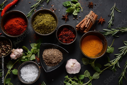 Variety of spices and herbs on kitchen table. Colorful various herbs and spices for cooking on dark background