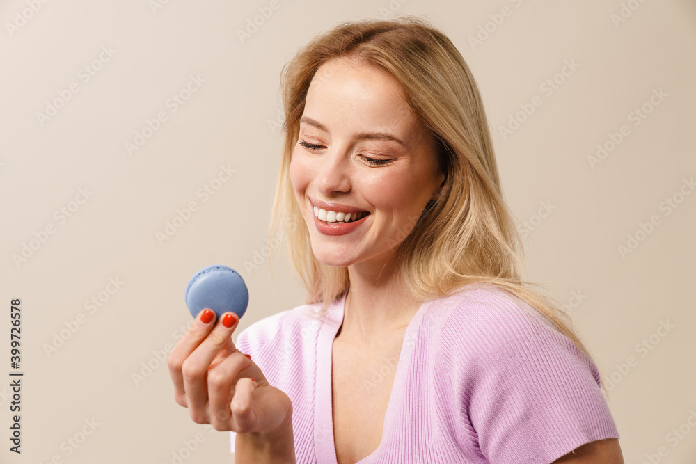 Happy beautiful girl smiling while posing with macaroon Happy beautiful girl smiling while posing with macaroon