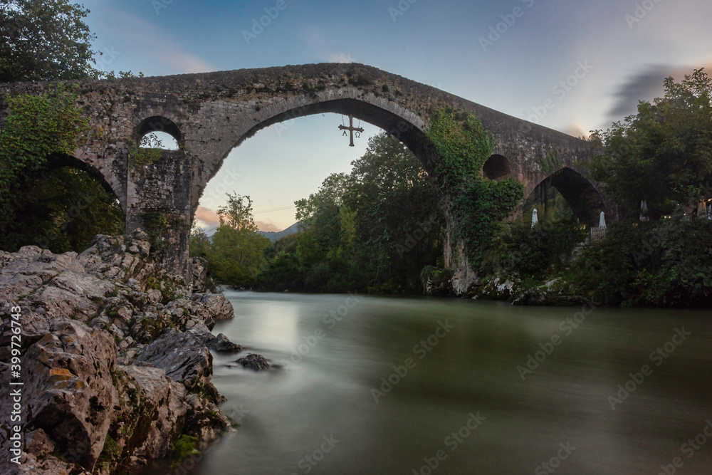 long exposure of the medieval stone bridge and the river with silk effect
