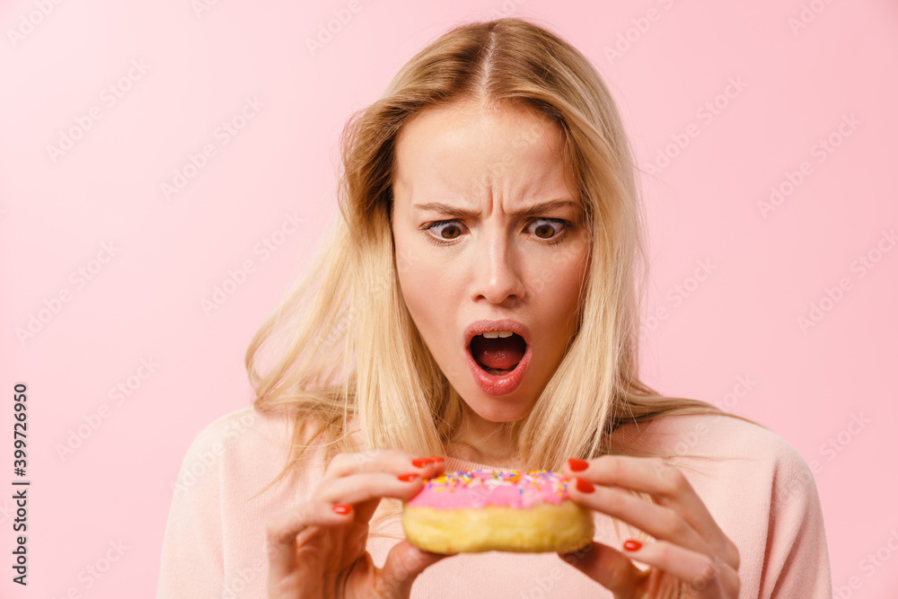 Shocked charming blonde girl posing with doughnut Shocked charming blonde girl posing with doughnut