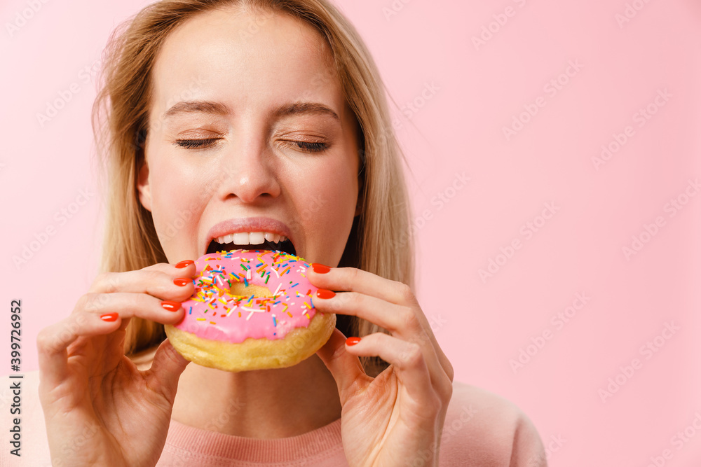 Pleased charming hungry girl eating doughnut on camera