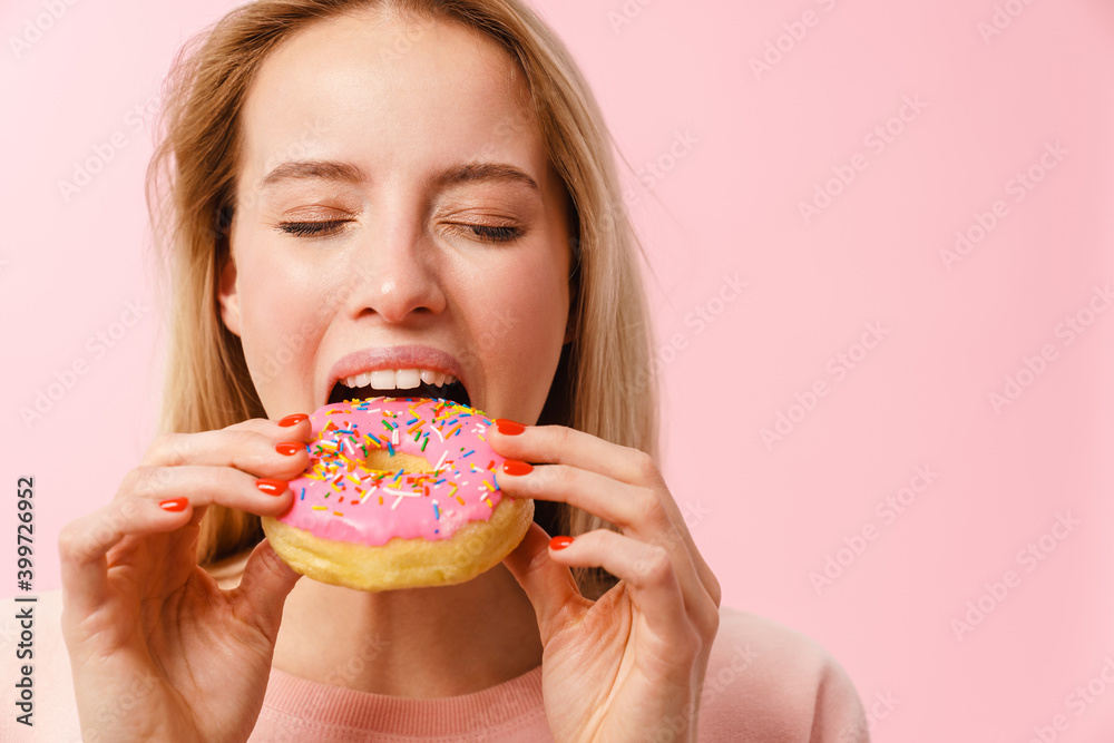 Pleased charming hungry girl eating doughnut on camera Pleased charming hungry girl eating doughnut on camera